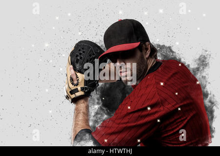 Joueur de baseball avec un uniforme rouge qui sort d'une explosion de fumée . Banque D'Images