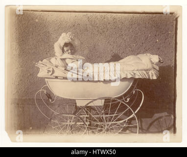 Photographie victorienne originale d'un bébé portant un capot en dentelle orné, assis dans un pram, Royaume-Uni Banque D'Images