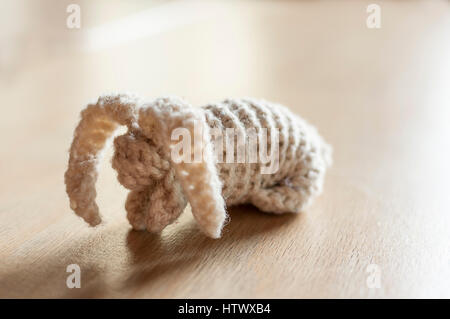 Lapin blanc sur la table en bois. Jouet en peluche à la main. Banque D'Images