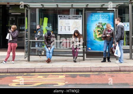 Les gens qui attendent à un arrêt d'autobus, Nottingham, England, UK Banque D'Images