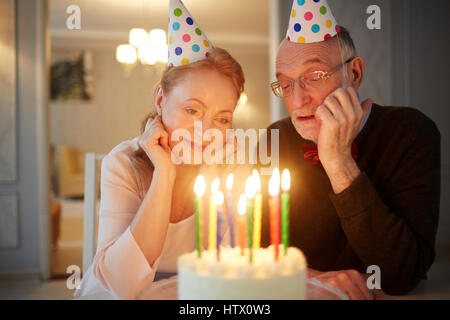 Portrait de senior couple relaxing together sitting at table with cake Banque D'Images