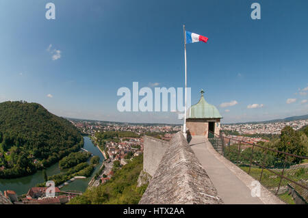 Drapeau tricolore français volant au-dessus d'une tour sur les remparts de la Citadelle de Besançon, France fort avec la rivière en bas à gauche Banque D'Images