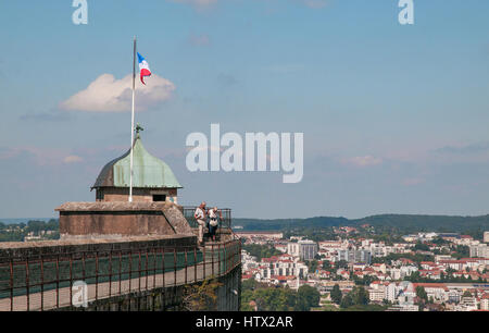 Drapeau tricolore français volant au-dessus d'une tour sur les remparts de la Citadelle de Besançon fort, en France. Deux personnes sont en ordre décroissant les marches de la tour Banque D'Images