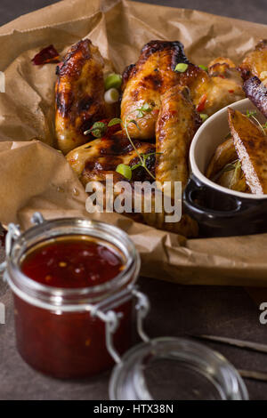 Ailes de poulet épicées avec Hot Chili de la confiture, des pommes de terre et les carottes violettes Banque D'Images