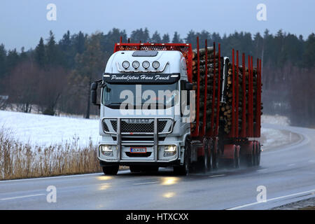 SALO, FINLANDE - le 10 mars 2017 : Kamaz 5460 blanc de grumier de Puukuljetus 560 Hans Funck transporte un chargement de billes sur route mouillée dans le bleu h Banque D'Images