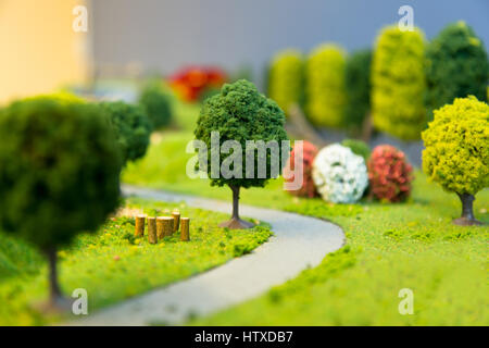 Paysage miniature d'un parc avec des arbres d'une petite route et l'herbe. Focus sélectif. Banque D'Images