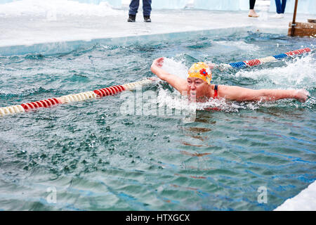 SAHYURTA ,Région d'Irkoutsk, RUSSIE - Mars 11,2017 : Tasse de Baikal. Piscine d'hiver. Papillon. Femme nage vigoureusement Banque D'Images