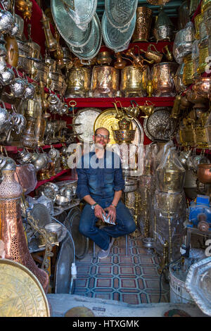 Fes, Maroc. Place Seffarine. Vendeur de plateaux en laiton et des ustensiles. Banque D'Images