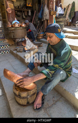 Fes, Maroc. Place Seffarine. Marteler un bol de cuivre artisan en forme. Banque D'Images