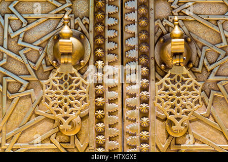 Fes, Maroc. Heurtoirs de porte en laiton sur le Dar El Makhsen, le palais du roi, Fes El Jedid. Banque D'Images