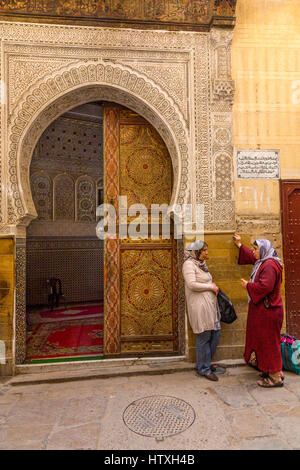 Fes, Maroc. Des femmes qui parlent à l'extérieur Entrée de Zawiya de Sidi Ahmed Tijani. Banque D'Images