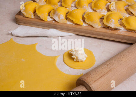 Vue rapprochée de la pièce ronde de pâte et fromage cottage ou caillé sur prêt pour préparer varenik ou dumpling ou pierogi. Prêt pour l'ébullition vareniki, Banque D'Images