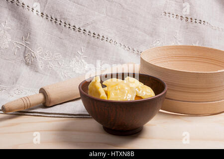 Bouillie fraîche des quenelles ukrainien avec du fromage cottage ou caillé et le beurre dans un bol d'argile sur fond de bois. Varenyky ou Knedlík ou pierogi j Banque D'Images