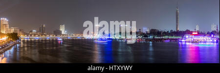 Vue panoramique du centre-ville du Caire, la nuit, le pont Kasr El Nil et l'île de Zamalek, avec ses bateaux colorés sur le Nil. Banque D'Images