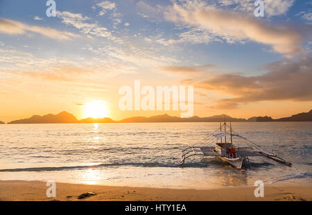 Banca traditionnels voile au coucher du soleil sur Ipil-Ipil plage près de l'île de Palawan, El Nido, Philippines Banque D'Images