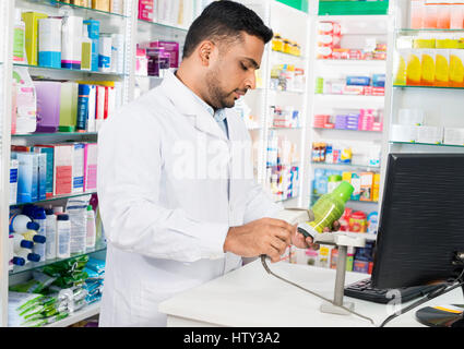 Balayage de code-barres du produit chimiste au comptoir Banque D'Images