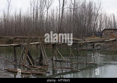 Srinagar, Inde. Mar 15, 2017. Une femme marche sur le pont de bois le Mercredi, Mars 15, 2017, dans la banlieue de Srinagar, dans le Cachemire sous contrôle indien. Credit : Umer Asif/Pacific Press/Alamy Live News Banque D'Images