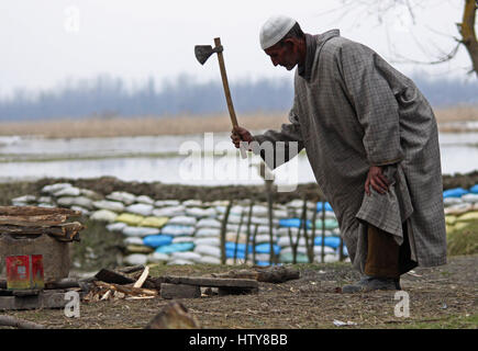 Srinagar, Inde. Mar 15, 2017. Un homme âgé couper un journal en bois le Mercredi, Mars 15, 2017, dans la banlieue de Srinagar, dans le Cachemire sous contrôle indien. Credit : Umer Asif/Pacific Press/Alamy Live News Banque D'Images