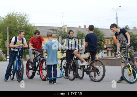 KOVROV, Russie - le 11 juillet 2015 : Place de la victoire. Groupe d'adolescents sur un scooter et vélos communiquent les uns avec les autres Banque D'Images