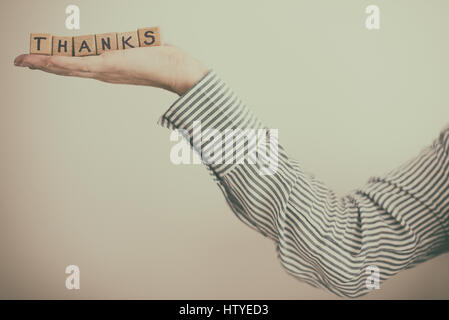 Woman's Hand holding blocs de construction en bois l'orthographe mot Merci Banque D'Images