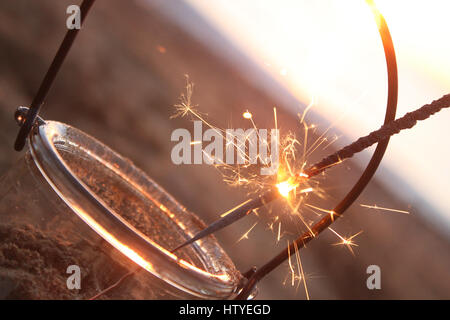 Allumé sparkler dans un pot sur la plage Banque D'Images