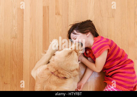 Vue de dessus de golden retriever dog licking visage de la fille. Banque D'Images