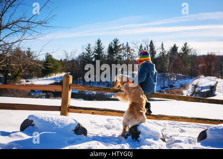 Boy and dog standing on fence Banque D'Images