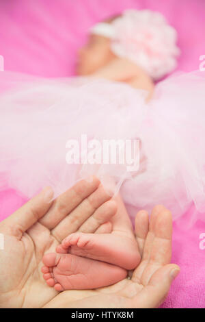 Woman's hands holding a baby girl's feet Banque D'Images