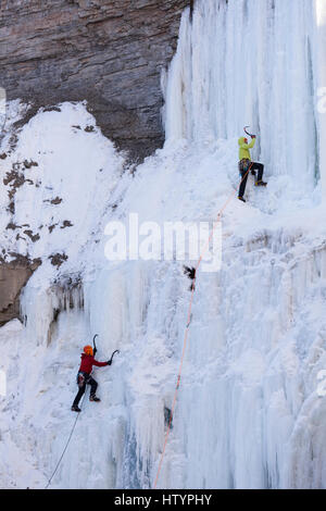 Les glaciéristes escalade la frozen Buttermilk Falls à Hamilton, Ontario, Canada. Banque D'Images