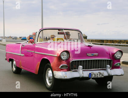 Une vieille voiture Chevrolet rose sur la route côtière à La Havane, Cuba Banque D'Images