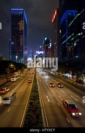 Une vue des gratte-ciel et le trafic avec flou de mouvement le long de la station Gloucester Road sur l'île de Hong Kong dans la soirée la nuit. Banque D'Images