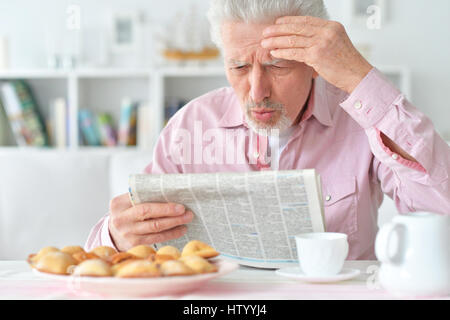 Vieil homme lit un journal Banque D'Images