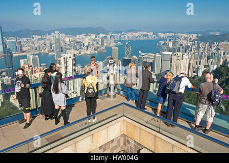 Les touristes de prendre des photos à partir de la terrasse Sky 428 sur le dessus de la tour de pointe sur Hong Kong et Victoria Bay sur une journée ensoleillée avec ciel bleu. Banque D'Images