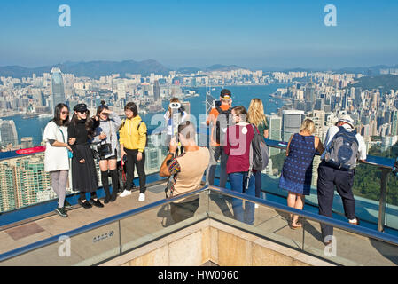 Les touristes de prendre des photos à partir de la terrasse Sky 428 sur le dessus de la tour de pointe sur Hong Kong et Victoria Bay sur une journée ensoleillée avec ciel bleu. Banque D'Images