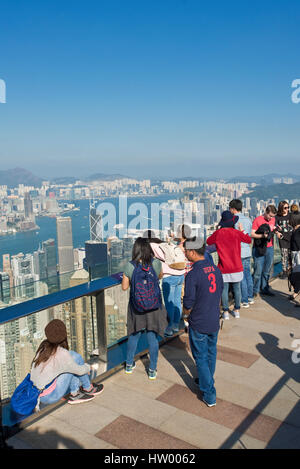 Les touristes de prendre des photos à partir de la terrasse Sky 428 sur le dessus de la tour de pointe sur Hong Kong et Victoria Bay sur une journée ensoleillée avec ciel bleu. Banque D'Images