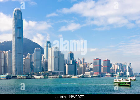 Un paysage urbain voir des bâtiments le long de l'île de Hong Kong avec une Star Ferry dans l'avant-plan sur une journée ensoleillée avec ciel bleu. Banque D'Images