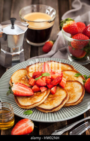 De délicieuses crêpes faites maison servi avec des fraises fraîches et de miel pour le petit déjeuner Banque D'Images