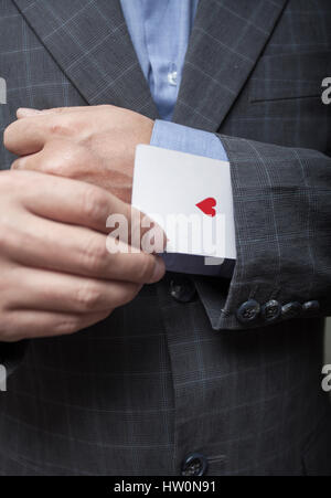 Man's hands close up, masquer un as dans un manchon Banque D'Images