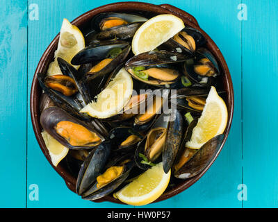 Les moules cultivées de corde dans une sauce à l'ail et l'échalote avec des tranches de citron