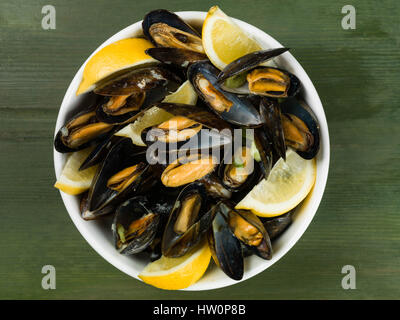 Les moules cultivées de corde dans une sauce à l'ail et l'échalote avec des tranches de citron