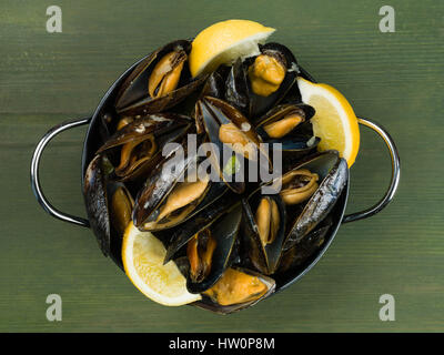Les moules cultivées de corde dans une sauce à l'ail et l'échalote avec des tranches de citron
