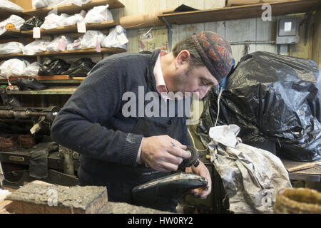 Européenne d'experts formés cordonnier travaille dans son atelier dans le quartier de Windsor Terrace, Brooklyn, New York. Banque D'Images