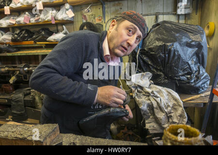 Européenne d'experts formés cordonnier travaille dans son atelier dans le quartier de Windsor Terrace, Brooklyn, New York. Banque D'Images