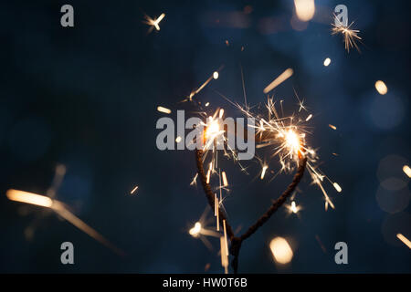 Forme de coeur sparkler brûler dans le noir Banque D'Images
