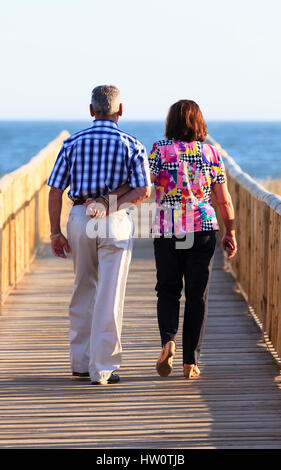 Couple sur la plage en bois passerelle, Punta Umbria, Espagne Banque D'Images