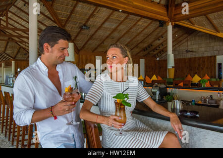 Les Maldives, Rangali Island. Conrad Hilton Resort. Couple au bar ayant des boissons. (MR) Banque D'Images