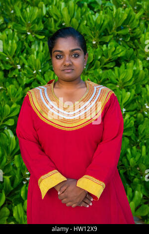 Les Maldives, Rangali Island. Conrad Hilton Resort. Femme en robe traditionnelle aux Maldives. Banque D'Images