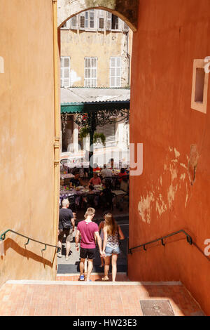 Jeune couple marche main dans la main vers le bas comme suit dans l'un des nombreux passages étroits à Grasse, en Provence, dans les Alpes françaises. Banque D'Images