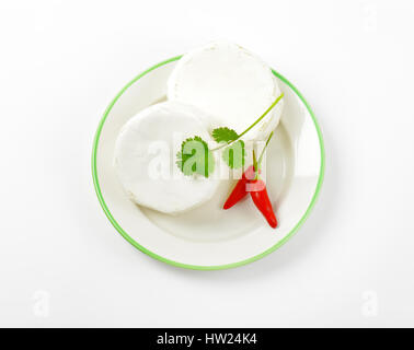 Roues de fromage blanc et de piment rouge sur la plaque Banque D'Images