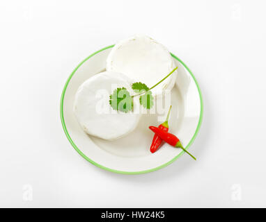 Roues de fromage blanc et de piment rouge sur la plaque Banque D'Images